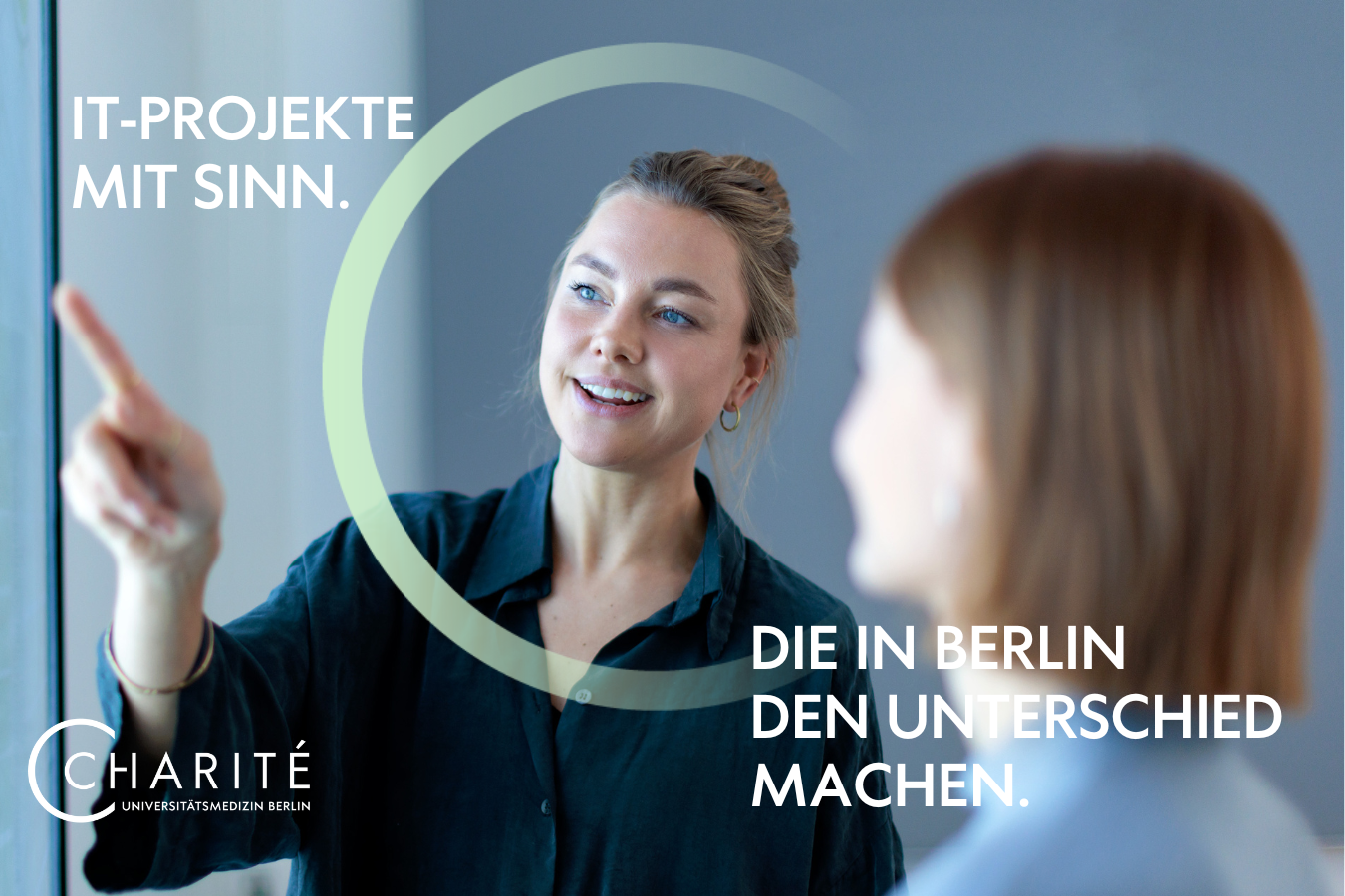 Eine Frau steht an einem Monitor und zeigt einer Kollegin etwas. Auf dem Bild steht - IT-Projekte mit Sinn. Die in Berlin den Unterschied machen.